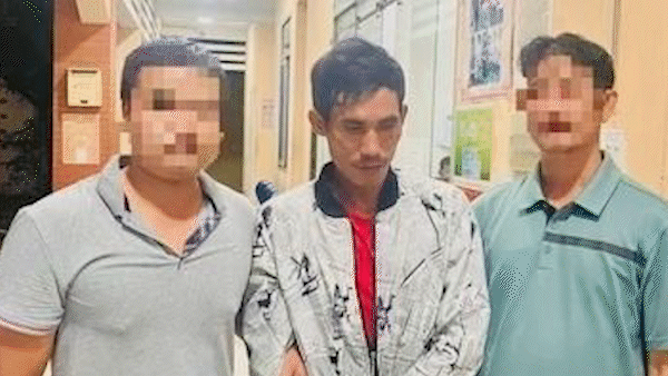 Lê Văn Tình (giữa) lúc bị đưa về trụ sở công an 