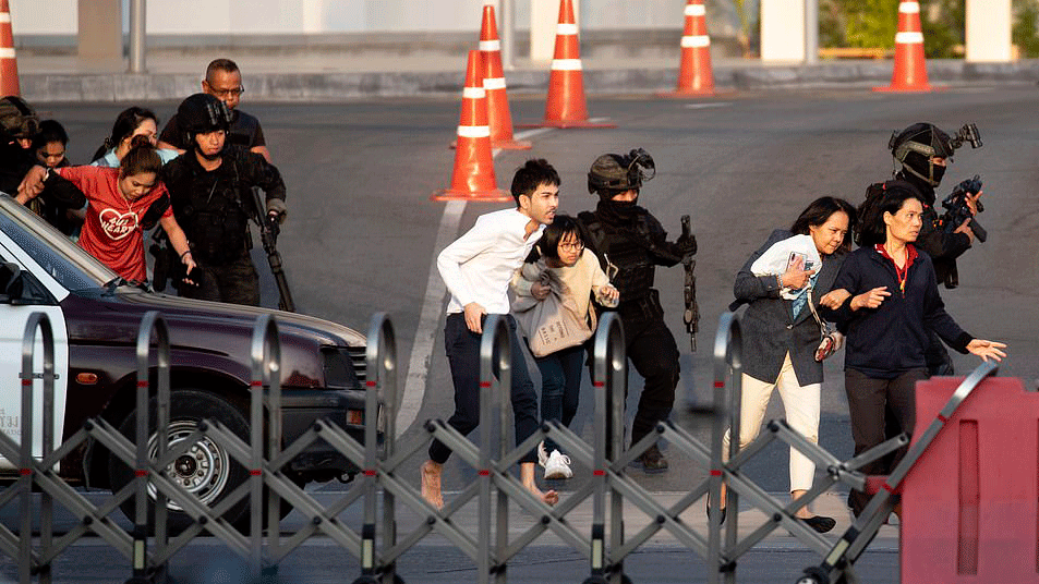 Lực lượng đặc nhiệm hỗ trợ người dân sơ tán khỏi trung tâm tâm thương mại.  Ảnh: AP