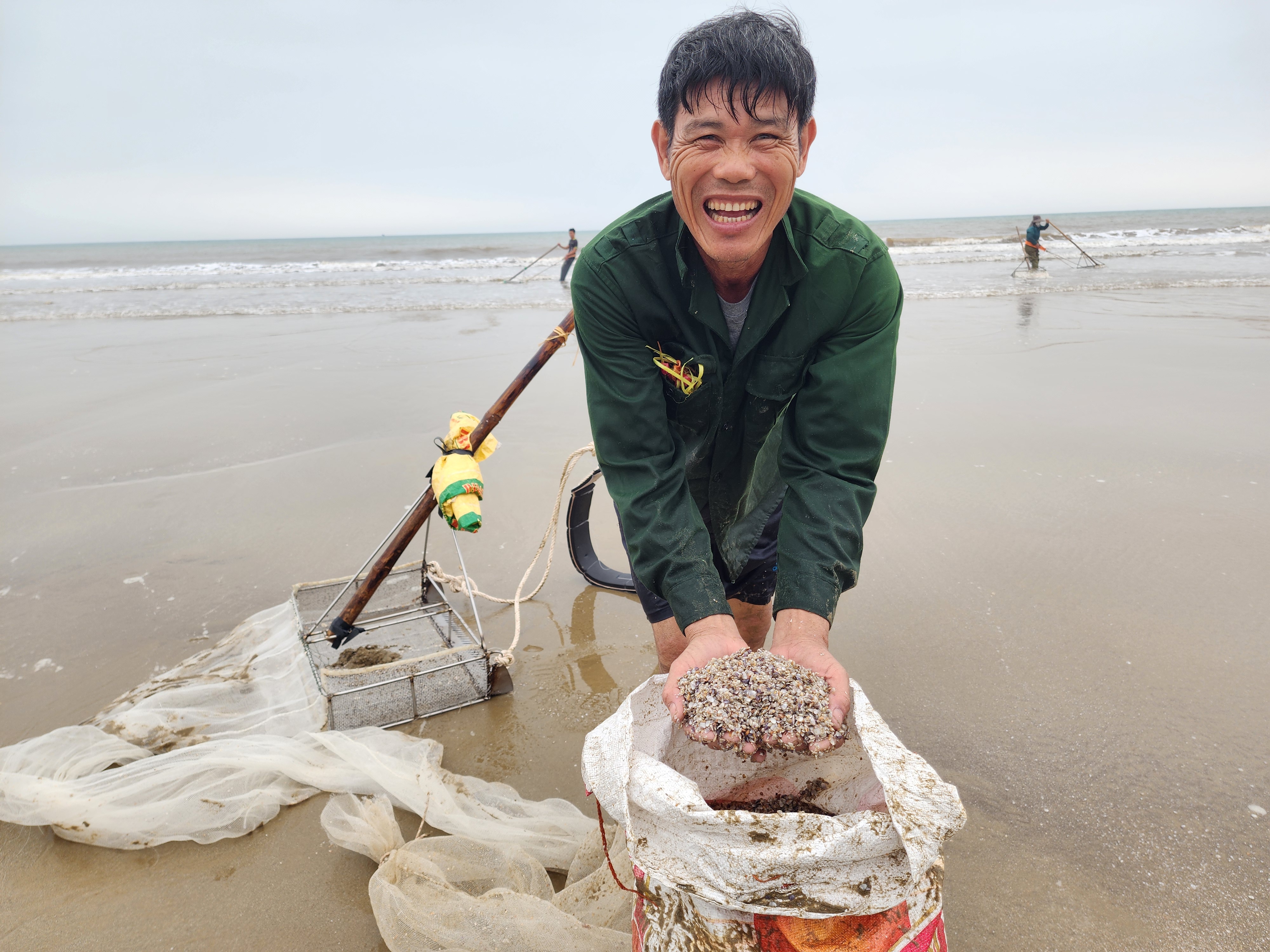 Người dân phấn khởi cào được nhiều ốc tép biển
