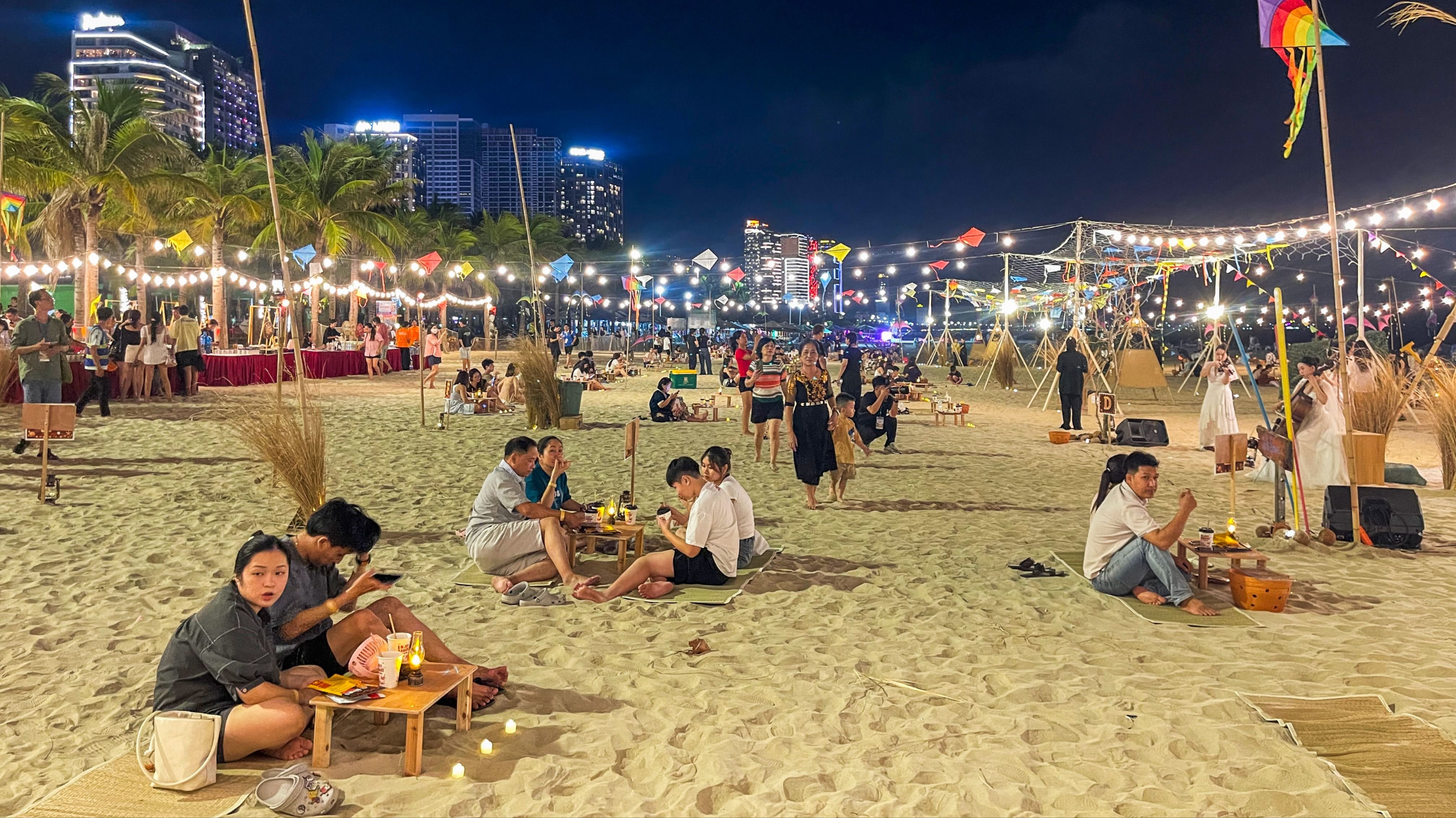Không gian biển đêm được phủ bởi hàng trăm cụm đèn nghệ thuật, kết hợp bàn tiệc ven biển, ánh nến, đèn dầu và âm nhạc acoustic, tạo nên điểm nhấn mới cho du lịch đêm