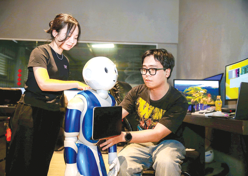 Nhân viên Công ty TNHH MTV Phát triển phần mềm Âu Lạc (Alta Software) kiểm tra tình trạng của Robot TESTU. Ảnh: HOÀNG TRIỀU