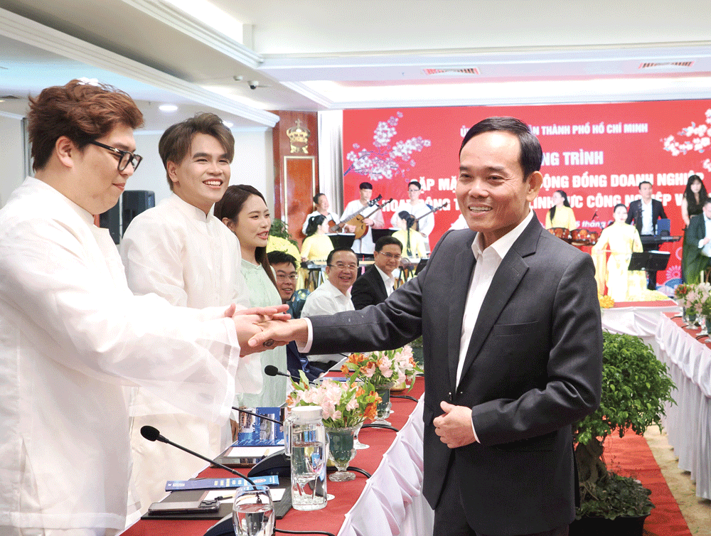 Bí thư Thành ủy TPHCM Trần Lưu Quang trao đổi với nhóm sản xuất âm nhạc DTAP tại chương trình Gặp mặt thân mật cộng đồng doanh nghiệp hoạt động trong các lĩnh vực công nghiệp văn hóa do UBND TPHCM tổ chức, ngày 5-2. Ảnh: HOÀNG HÙNG