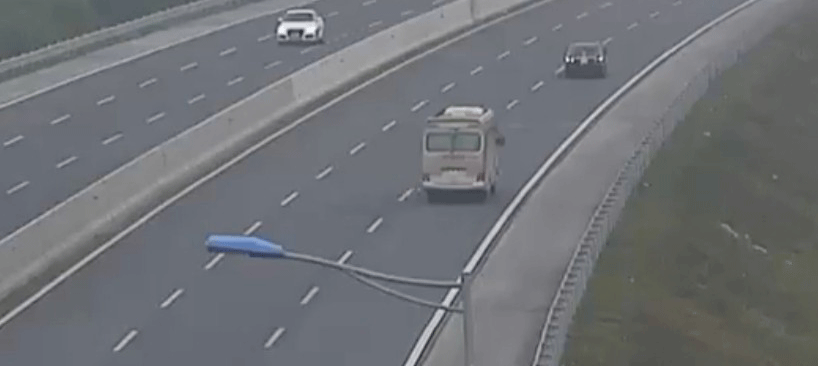 Xe con màu đen đi lùi trên cao tốc suýt va chạm với xe khách.  Ảnh chụp từ clip