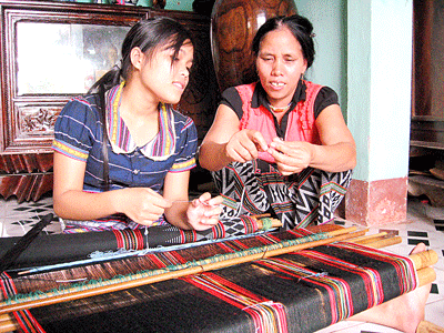 Mai Thi Hop teaching ‘Zeng’ weaving to a young girl (Photo: SGGP)