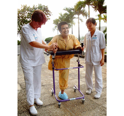 Medical workers help Hai to walk in the FV Hospital premises (Photo: SGGP)