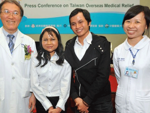 Nguyen Thi Ngoc Mai (2nd L) stands with her plastic surgeon Hung-Chi Chen (L) at the press conference