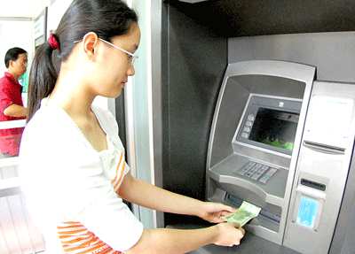 Client withdraws money from an ATM machine on Bui Thi Xuan Street in District 1, HCMC (Photo: SGGP)