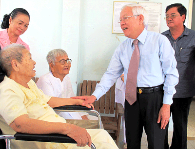 Le Hoang Quan, chairman of the HCMC People’s Committee, talks to a heroic mother in hospital (Photo: SGGP)
