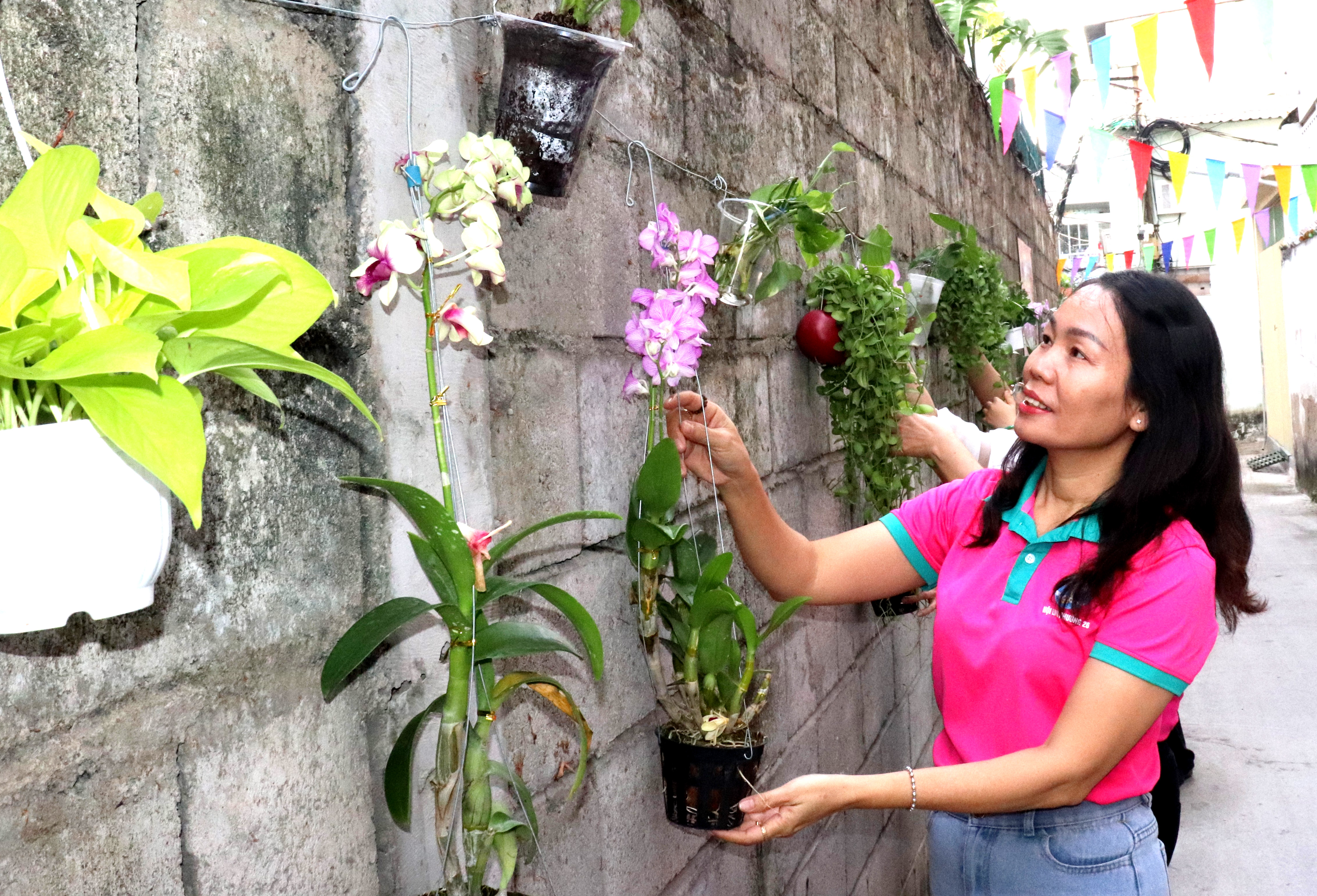 Phụ nữ khu phố 50 (phường Bình Thạnh) chăm sóc công trình “Góc phố Bình Thạnh – Tường hoa rực rỡ”