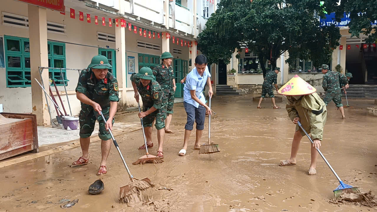 Dọn dẹp lớp bùn còn đọng lại sau lũ tại một trường học