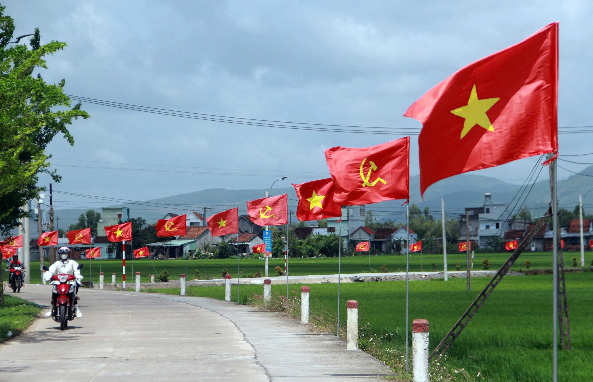 Những con đường rợp cờ Tổ quốc và cờ Đảng ở xã Hòa Thịnh (tỉnh Đắk Lắk), nơi có 110 ngôi nhà xây mới trong Chiến dịch Quang Trung. Ảnh: LỆ ĐÍNH