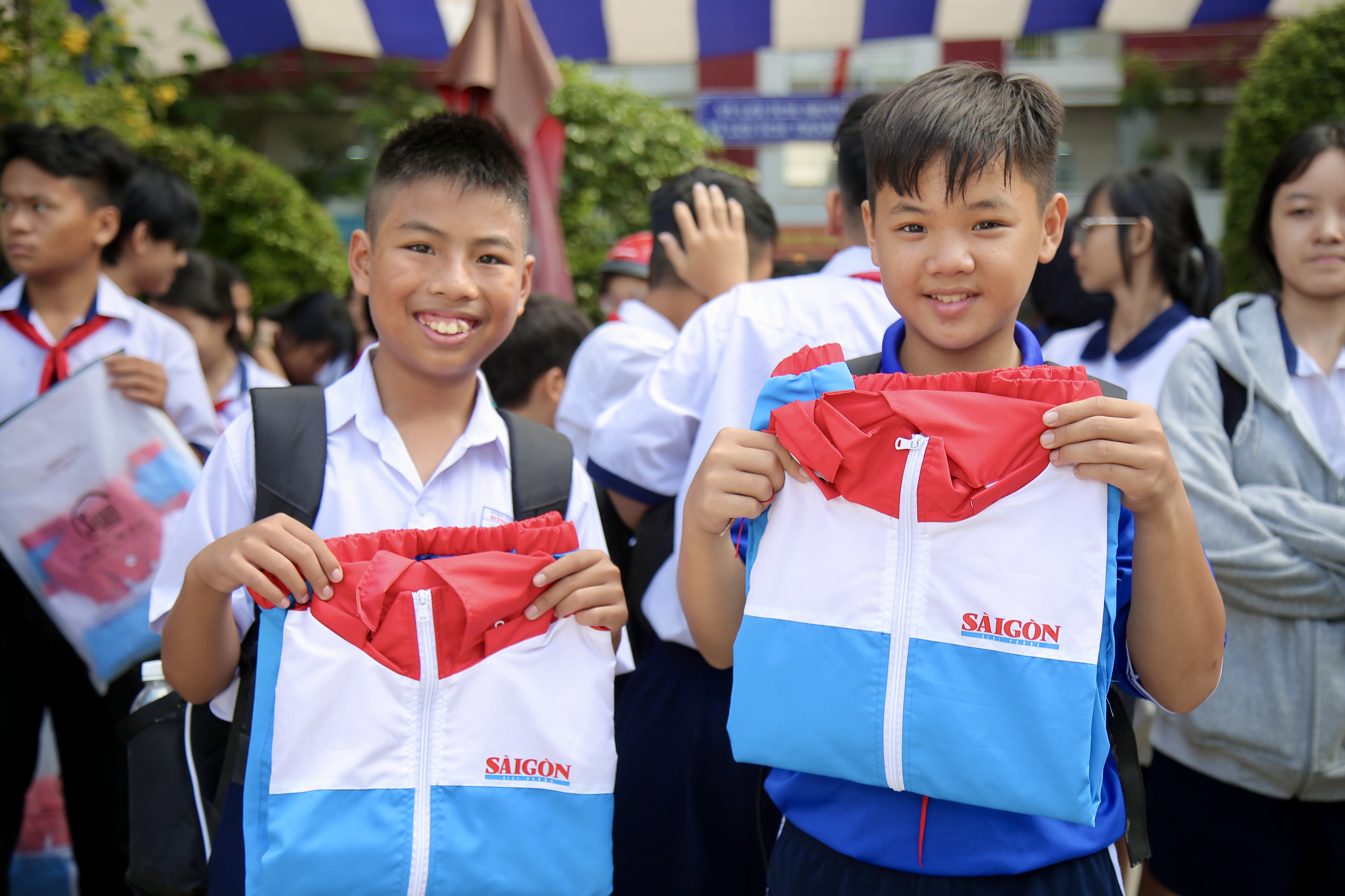 Niềm vui của các em học sinh tại xã Bình Lợi khi được nhận những chiếc áo ấm từ chương trình "Áo ấm đến trường". Ảnh: DŨNG PHƯƠNG 