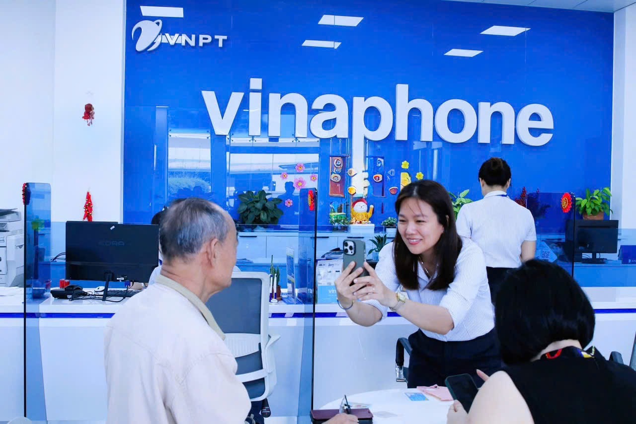 Nhân viên VinaPhone giúp khách hàng xác nhận sinh trắc học đăng ký thuê bao di động.