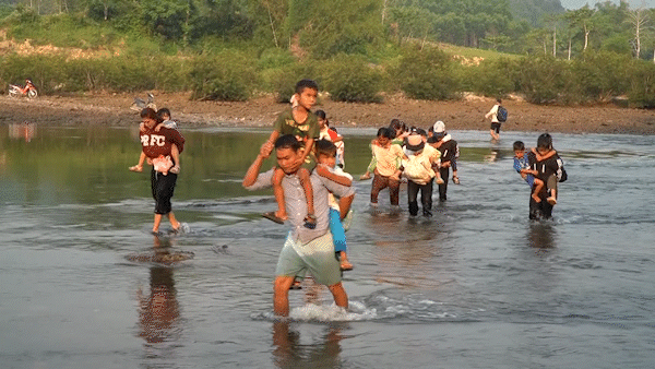 Quảng Ngãi: Phụ huynh cõng con vượt dòng nước xiết đến trường