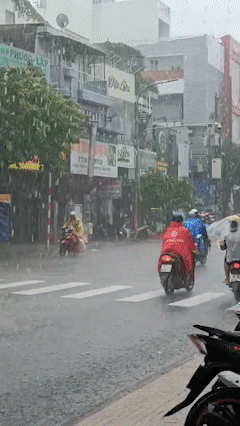 Người dân TPHCM "đội mưa" đi làm trong sáng 30-9