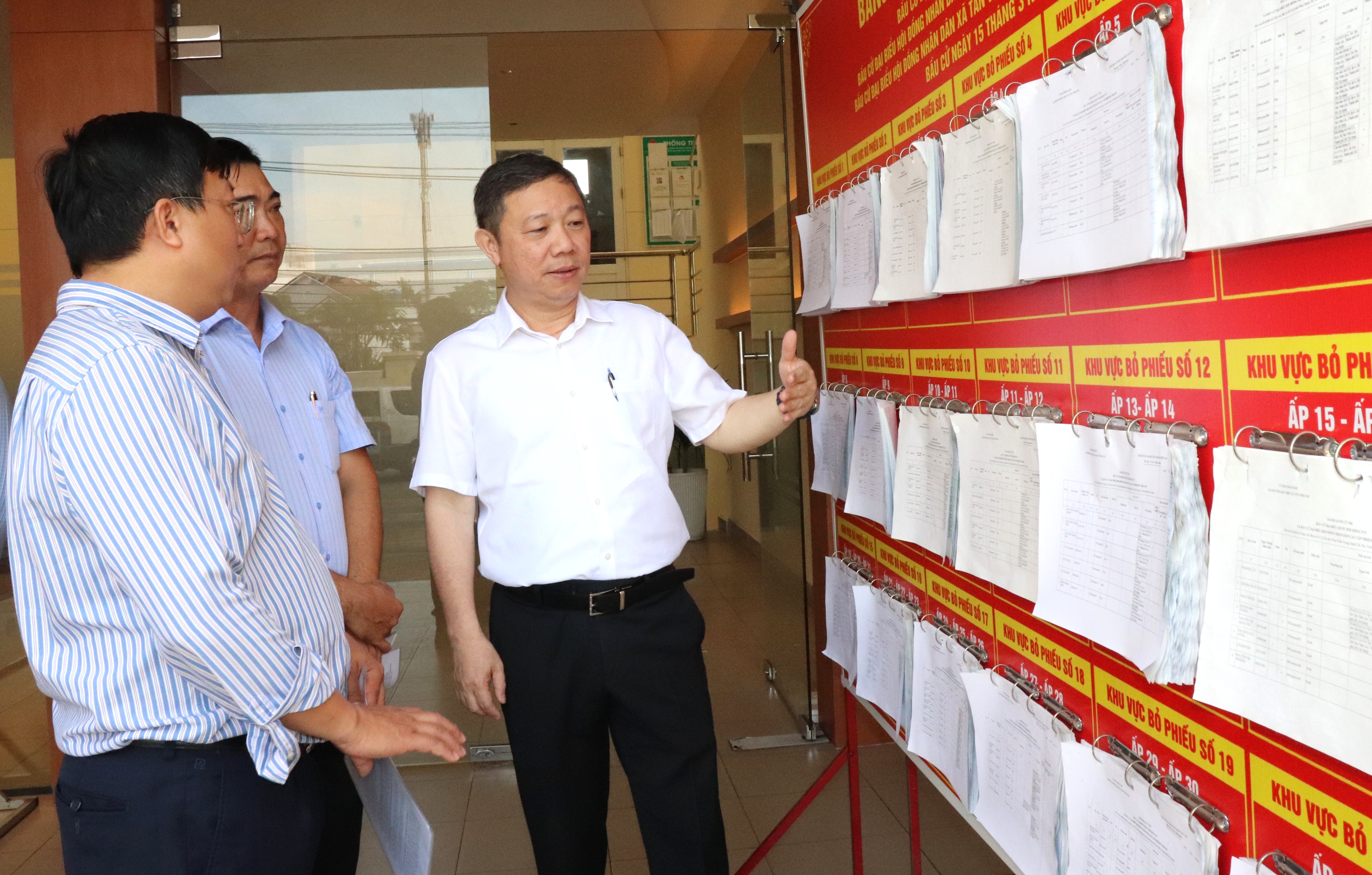 Trưởng Ban Tuyên giáo và Dân vận Thành ủy TPHCM Dương Anh Đức kiểm tra khu vực niêm yết danh sách người ứng cử tại điểm bỏ phiếu xã Tân Vĩnh Lộc. Ảnh: THÁI PHƯƠNG