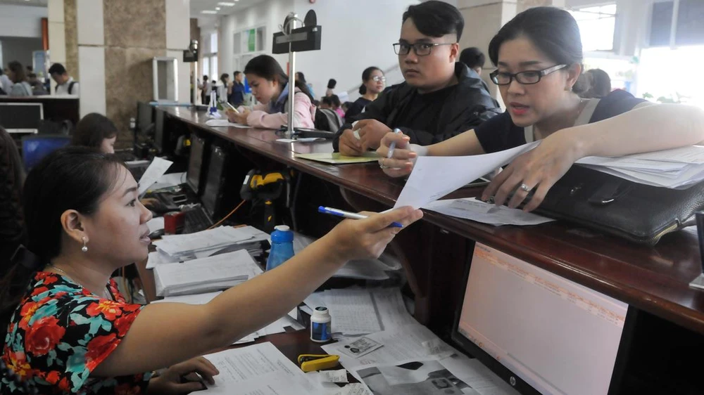 Doanh nghiệp nêu thắc mắc với nhân viên Cục Thuế TPHCM. Ảnh: CAO THĂNG