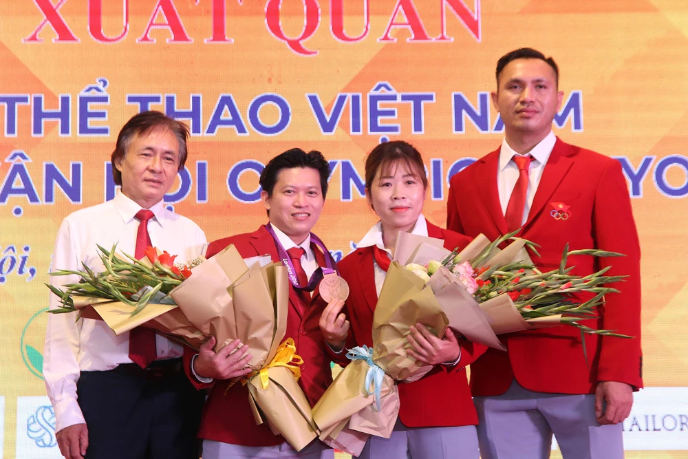 Cựu lực sĩ Trần Lê Quốc Toàn (thứ 2 từ trái qua) nhận HCĐ Olympic London 2012. Ảnh: MINH CHIẾN
