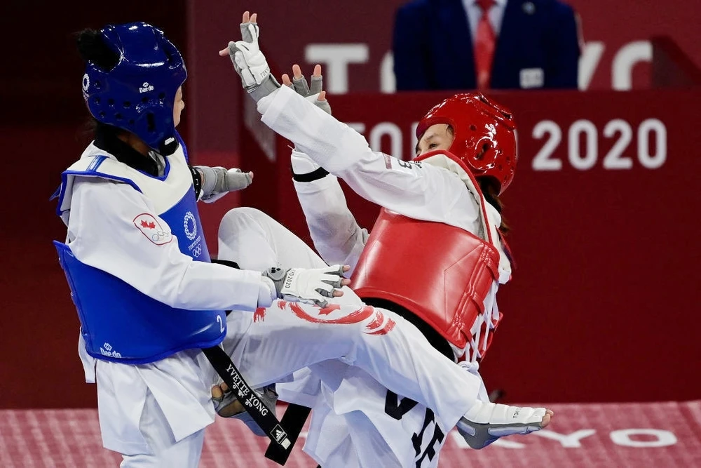 Trương Thị Kim Tuyền (phải) giành chiến thắng 19-5 trước võ sĩ Canada. Ảnh: Getty Images