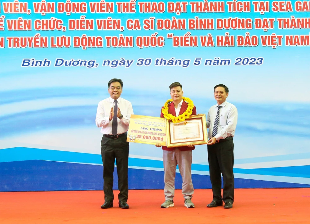 Ông Nguyễn Văn Lộc - Chủ tịch HĐND tỉnh và ông Nguyễn Lộc Hà - Phó Chủ tịch UBND tỉnh Bình Dương thừa ủy quyền của Thủ tướng Chính phủ, trao bằng khen của Thủ tướng và tiền thưởng cho VĐV Lại Lý Huynh