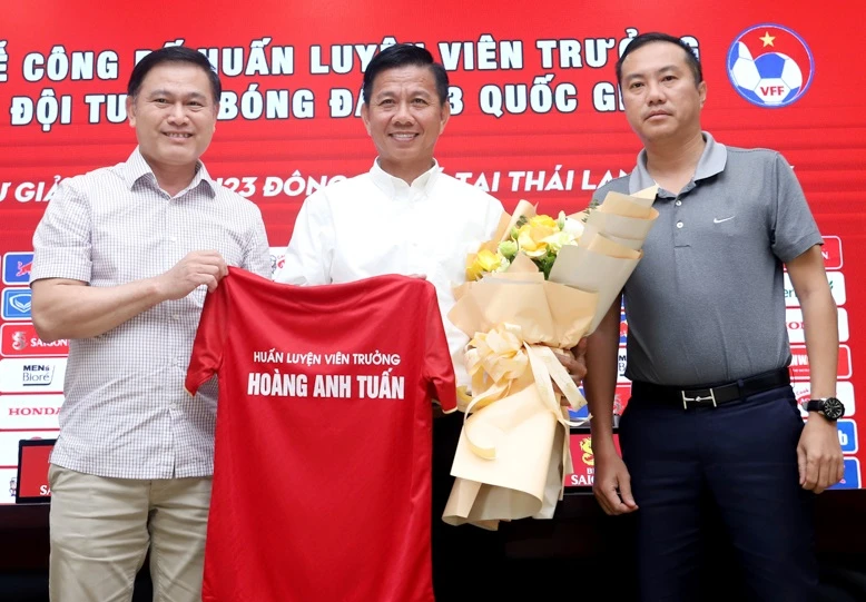Hai phó chủ tịch VFF Trần Anh Tú và Nguyễn Xuân Vũ tráo tặng áo và hoa đến HLV Hoàng Anh Tuấn