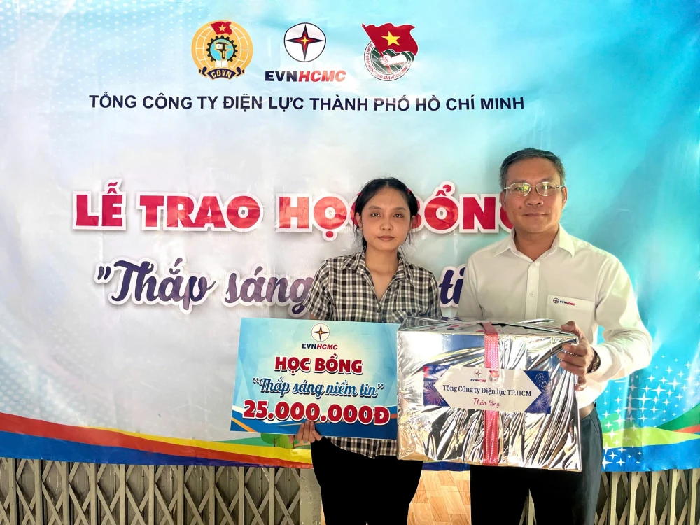 Phó Tổng Giám đốc EVNHCMC Bùi Trung Kiên trao quà và học bổng cho em Lê Ngọc Như Ý (xã Thái Mỹ, huyện Củ Chi, TPHCM)