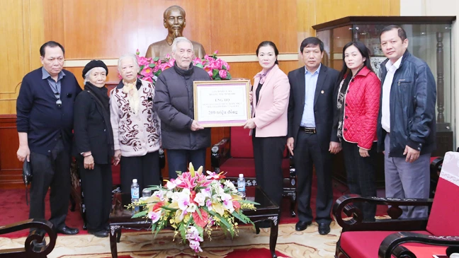 Đại diện gia đình cụ Hoàng Thị Minh Hồ trao tiền ủng hộ đồng bào miền Trung