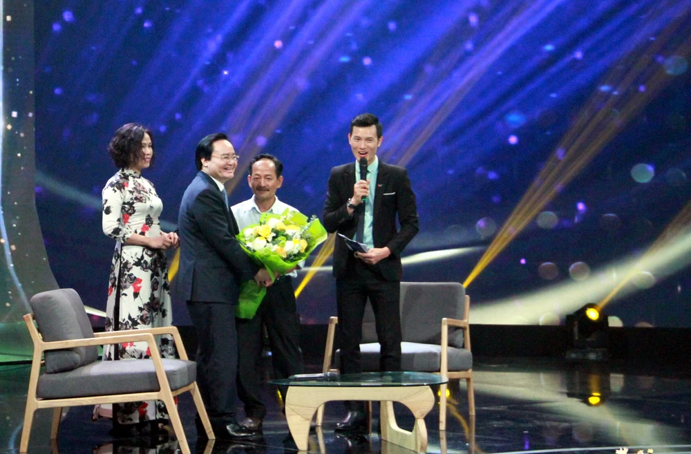 Bộ trưởng Bộ GD-ĐT Phùng Xuân Nhạ tặng hoa cho thầy Lưu Văn Hóa
