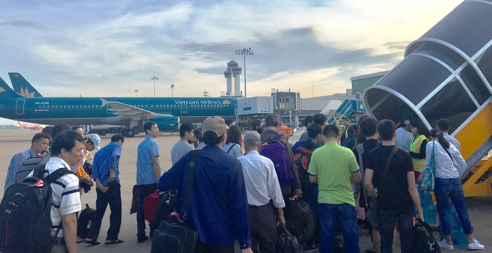 Người dân xếp hàng chuẩn bị lên máy bay tại Sân bay Tân Sơn Nhất