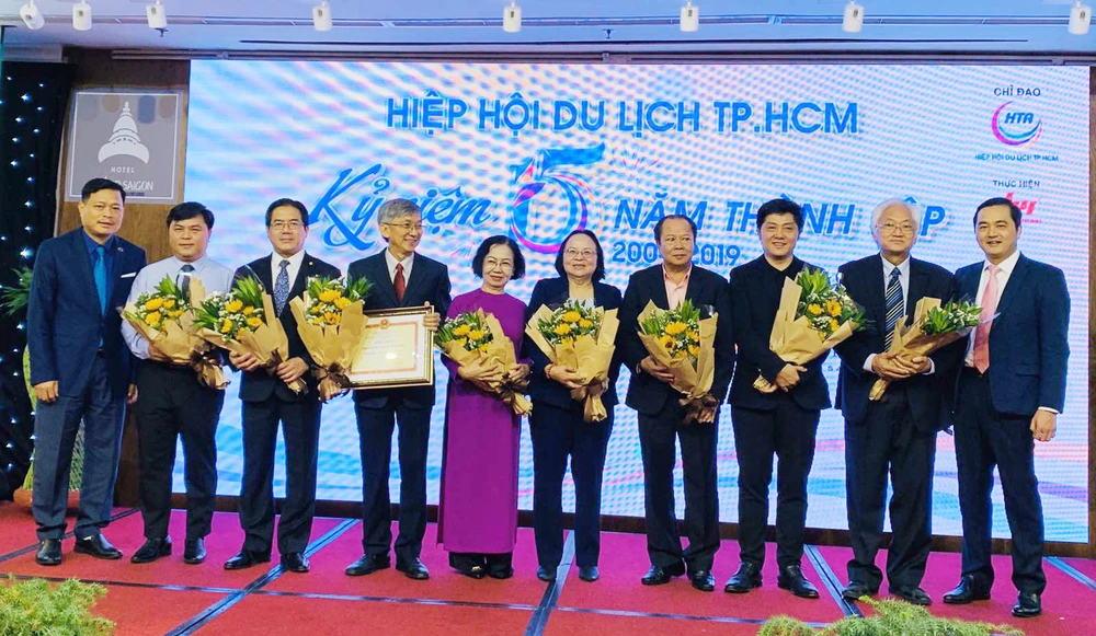Các lãnh đạo, thành viên Hiệp hội Du lịch TPHCM nhận hoa chúc mừng ngày 11-1. Ảnh: THI HỒNG