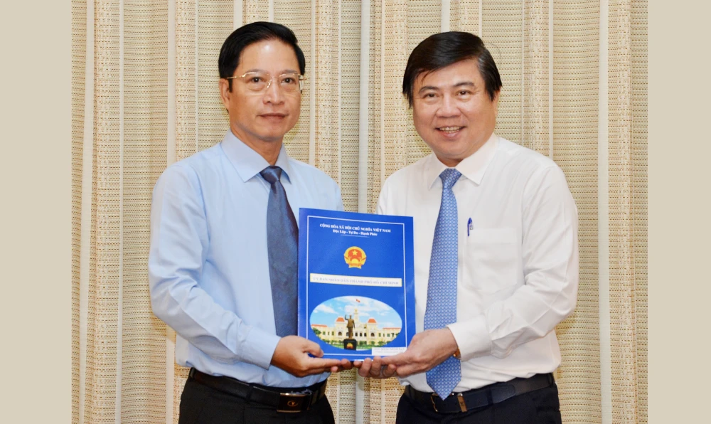 Đồng chí Nguyễn Thành Phong, Chủ tịch UBND TPHCM trao quyết định tiếp nhận và bổ nhiệm đồng chí Đặng Minh Đạt làm Chánh Thanh tra TPHCM. Ảnh: VIỆT DŨNG 
