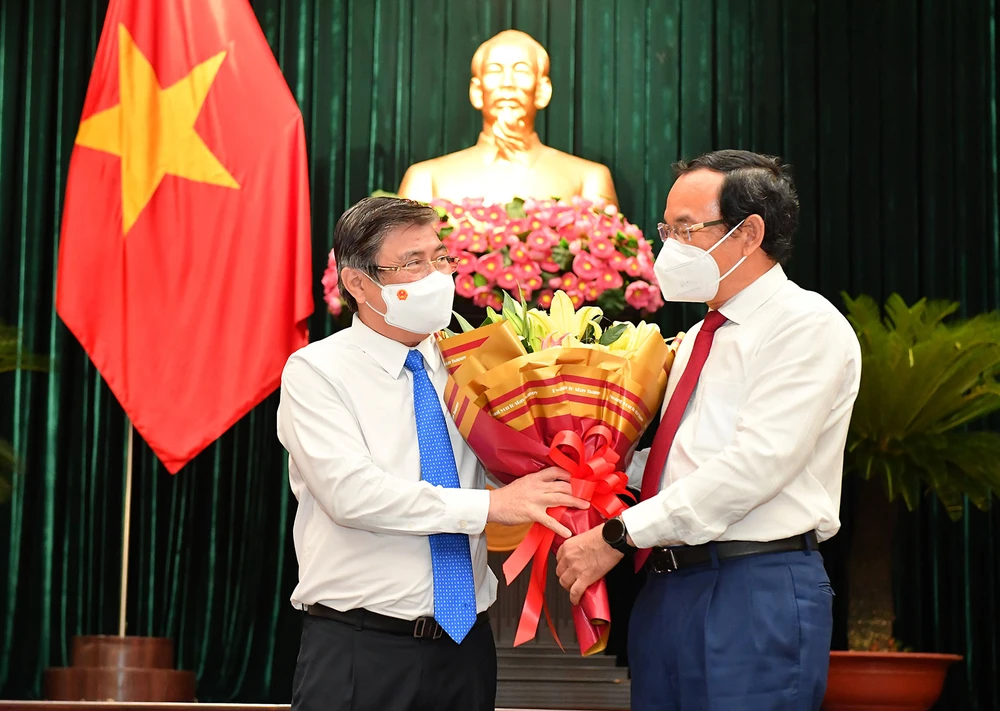 Bí thư Thành ủy TPHCM Nguyễn Văn Nên tặng hoa cho đồng chí Nguyễn Thành Phong tại kỳ họp thứ hai HĐND TPHCM khóa X, ngày 24-8. Ảnh: VIỆT DŨNG