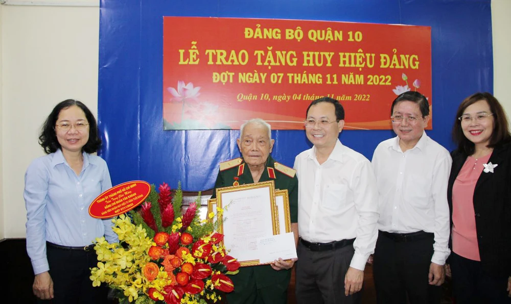 Phó Bí thư Thành ủy Nguyễn Văn Hiếu trao tặng Huy hiệu 75 năm tuổi Đảng cho Thiếu tướng Đoàn Văn Khoan. Ảnh: TRẦN YÊN