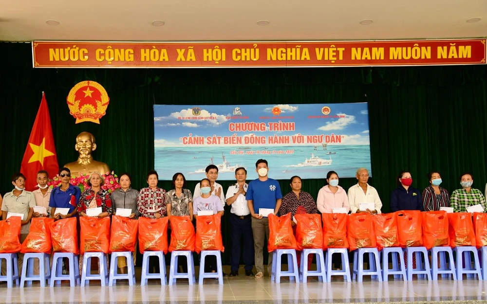 Thiếu tướng Đỗ Hồng Đó, Chính ủy Bộ Tư lệnh Vùng Cảnh sát biển 3 (người mặc quân phục đứng giữa) cùng lãnh đạo chính quyền địa phương trao quà cho gia đình chính sách, ngư dân. Ảnh: TRẦN YÊN