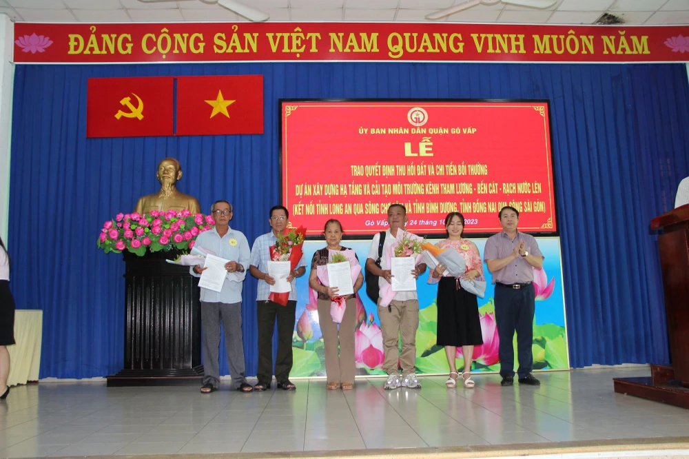 Chủ tịch UBND quận Gò Vấp Nguyễn Trí Dũng trao quyết định và hoa cho các hộ dân