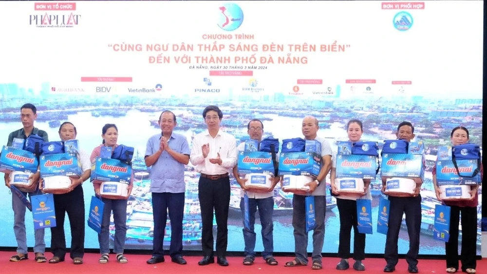 Nguyên Phó Thủ tướng Thường trực Chính phủ Trương Hòa Bình và Phó Chủ tịch UBND TP Đà Nẵng Trần Chí Cường trao quà tặng cho ngư dân. Ảnh: XUÂN QUỲNH