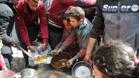 Người dân Palestine tại Dải Gaza xếp hàng chờ phát đồ ăn. Ảnh: REUTERS