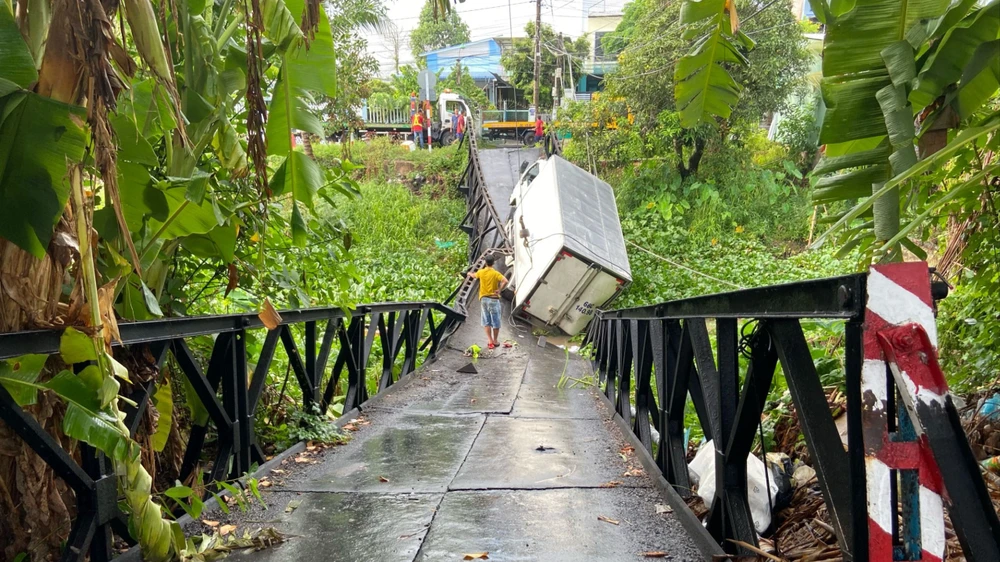 Cầu bị gãy đoạn giữa, một ô tô tải bị kẹt giữa cầu. Ảnh: PM