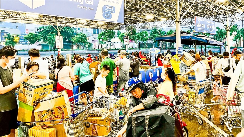 Người dân chờ đóng gói thực phẩm tại siêu thị MM Mega Market Hiệp Phú, quận 12, TPHCM. Ảnh: NGUYỄN TRUNG