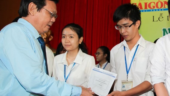 SGGP Editor-in-Chief Nguyen Tan Phong gives the scholarships to students at the ceremony (Photo: SGGP)