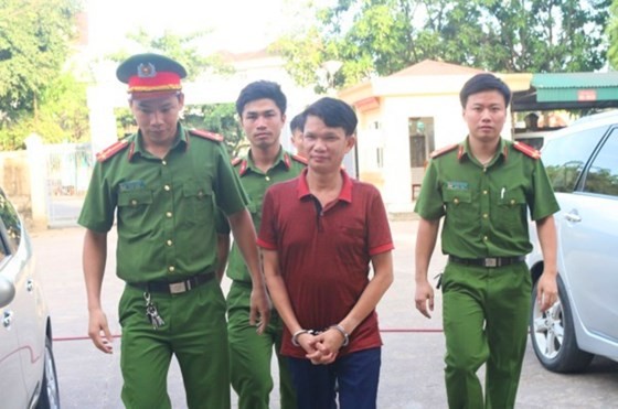 The director who commits tax evasion is escorted by police officers (Photo: SGGP)