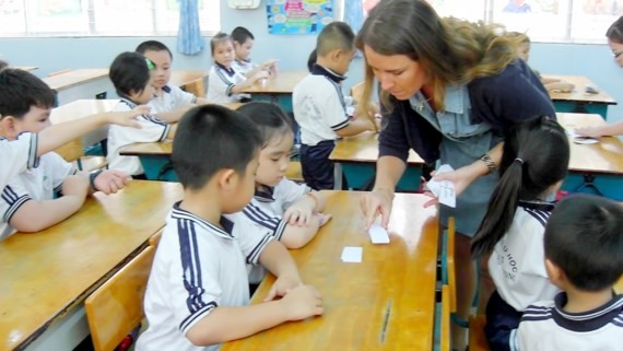 Foreign teacher teach Maths to kids in the program (Photo: SGGP)