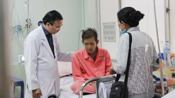 A medical worker talks to the Cambodian man about his health condition (Photo: SGGP)