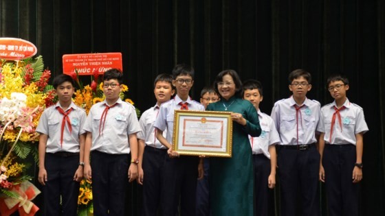 Than Thi Thu ( in green Ao Dai), head of the Ho Chi Minh City Party Committee's Commission for Propaganda and Education, hands certificates of merit to a good student (Photo: SGGP)