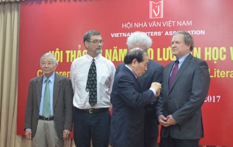 Huu Thinh, Chairman of the Vietnam Alliance of Arts and Literature Associations and the Vietnam Writers' Association, presented insignia for the Vietnamese art and literature cause. (Photo: vietnamnet)
