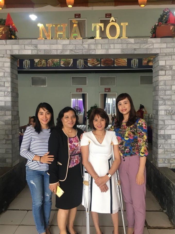 My Home: Trang stands with customers outside her restaurant.— Photo courtesy of Nguyen Thi Dai Trang