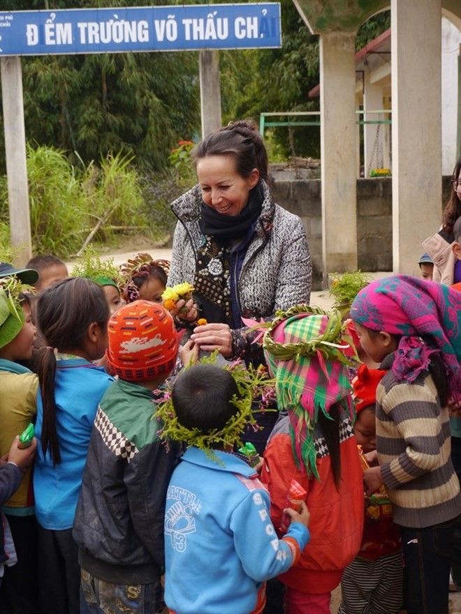 Isabelle Muller, the founder of Lo-ANH Foundation, is welcomed by the students of the elementary school in Vo Thau Chai, Hoang Su Phi district in Ha Giang Province. The school has been extended within the project No.8 of the foundation. (Photo courtesy of