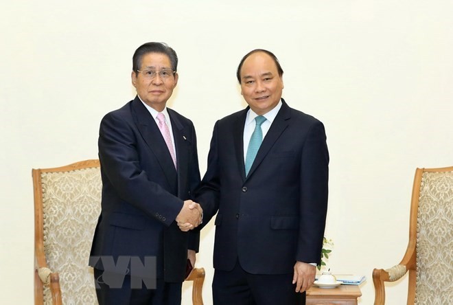 Prime Minister Nguyen Xuan Phuc shakes hands with Special Advisor to the Japanese Cabinet Isao Iijima at their meeting in Hanoi on March 23. (Photo: VNA)