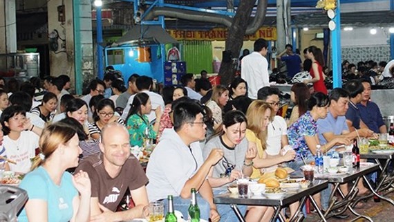 People enjoy their dishes in the new food street (Photo: SGGP)