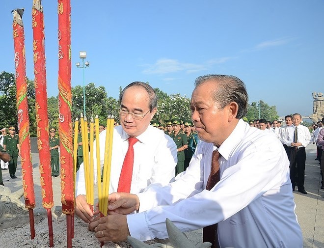 Politburo member and Standing Deputy Prime Minister Truong Hoa Binh (R) and Politburo member and Secretary of the Ho Chi Minh City Party Committee Nguyen Thien Nhan offer incense to heroic martyrs (Photo: plo.vn)
